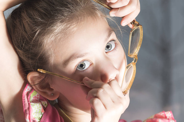Ребенок примеряет очки к лицу
 - Фото, изображение