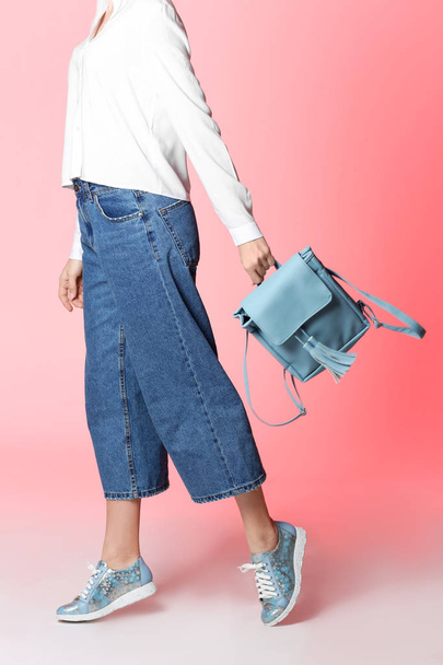 Woman in stylish shoes with backpack on color background - Fotografie, Obrázek