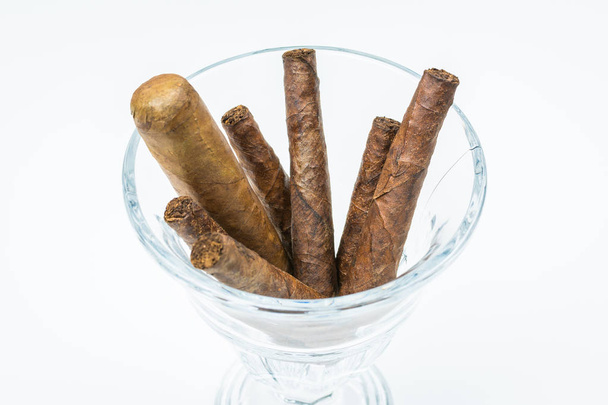 Thick cigars from twisted sheets in glass bowl with white background - Photo, Image