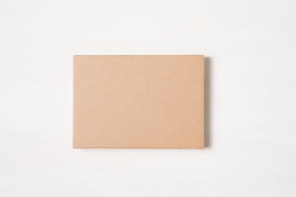 Крафт коричневый прямоугольный подарочная коробка на светлом фоне
 - Фото, изображение