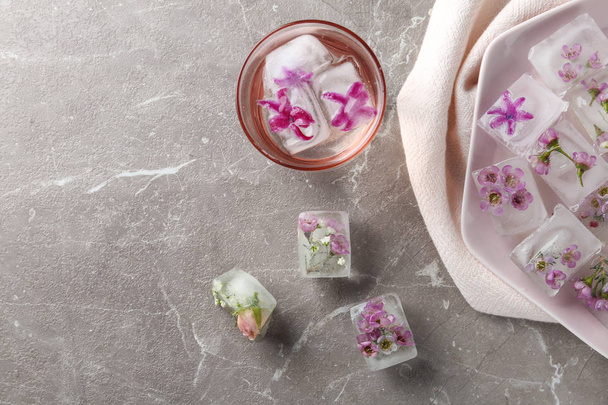 Flat lay composition with floral ice cubes on table. Space for text - Photo, Image