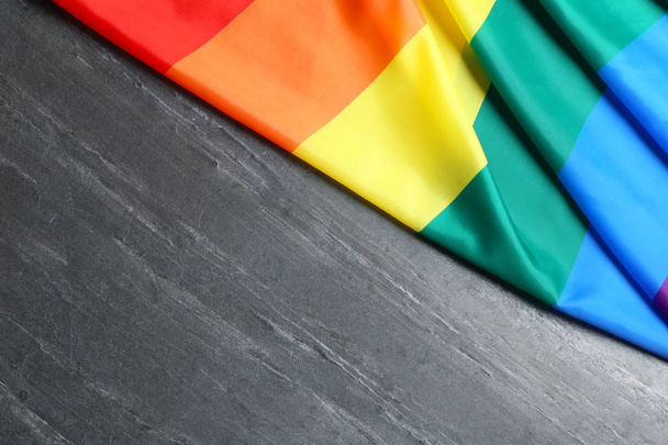 Bright rainbow gay flag on table, vista superior con espacio para el texto. Comunidad LGBT
 - Foto, imagen