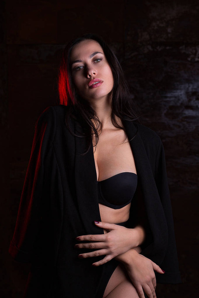 Amazing brunette girl wearing black lingerie posing with red lig - Photo, Image