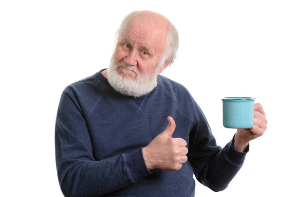 elderly man with cup of bad tea or coffee showing thumb up isolated on white - Photo, Image