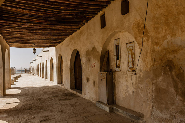 Katettu käytävä Aqeerin linnan julkisivulla Saudi-Arabiassa
 - Valokuva, kuva