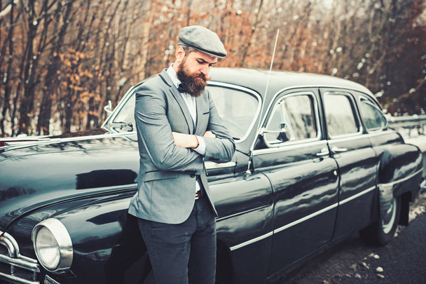 Call boy in vintage auto. Bearded man in car. Escort man or security guard. Retro collection car and auto repair by mechanic driver. Travel and business trip or hitch hiking - Fotó, kép