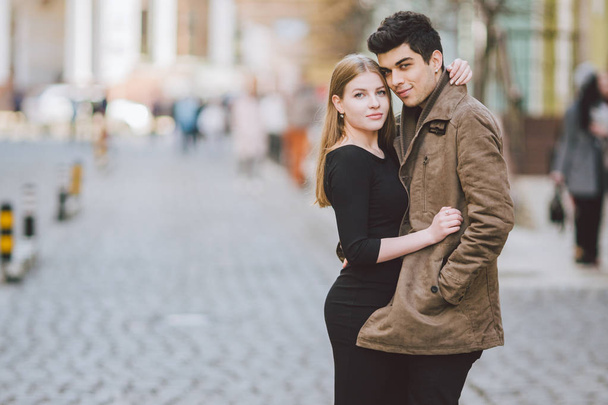 Városi modern, fiatal szerelmes pár gyaloglás romantikus beszélgetett, kezében a nap. Fiatal multikulturális török barna és kaukázusi pár a régi európai utcán. Tavaszi-őszi Időjárás - Fotó, kép
