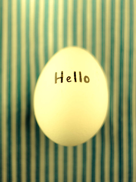 Белое куриное яйцо с черной надписью
 - Фото, изображение