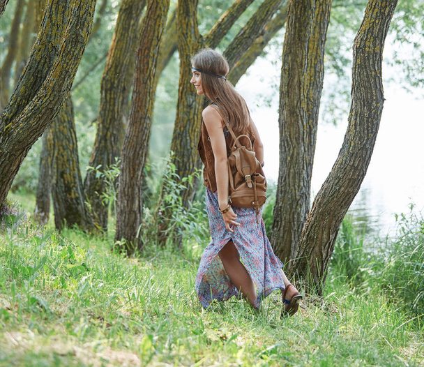 attractive hippie girl walking on a forest path - Photo, Image
