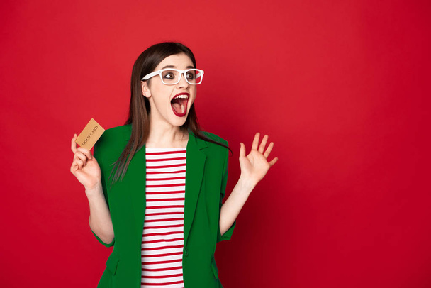 Happy surprised brunette lady with credit card - Photo, image