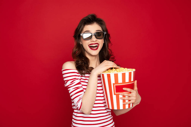 Happy brunette lady in 3D glasses and pop corn - 写真・画像