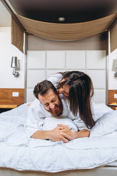 Imagen mostrando pareja feliz descansando en habitación de hotel
 - Foto, imagen