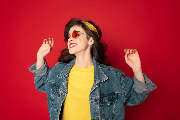 Cheerful hipster girl posing isolated on red - Foto, Imagem