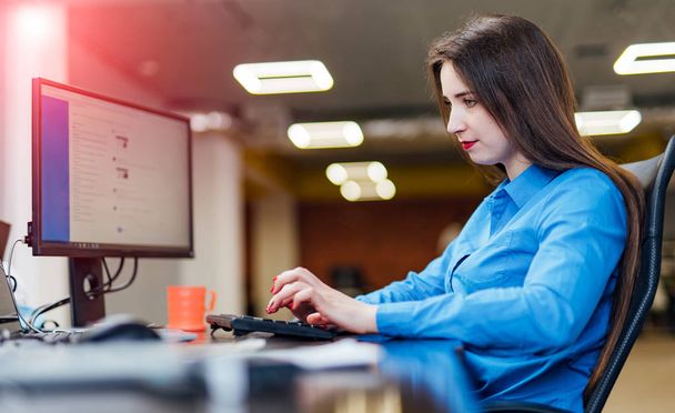 Software developer working on a computer at modern office. Beautiful young woman programming developing technologies in IT company. High quality image. - Фото, зображення