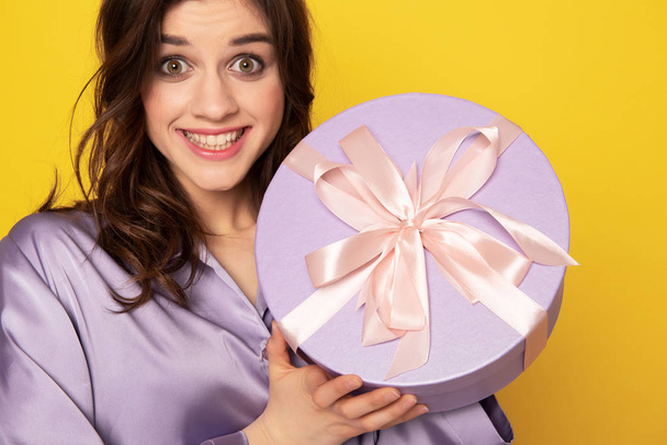 Cheerful pretty girl showing festive present box - Foto, Imagen