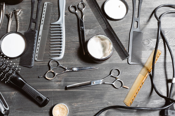 Набір професійних перукарів на сірому фоні. Дерев'яний стіл у перукарні. Робочий інструмент майстра перукарні
 - Фото, зображення