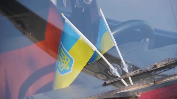 Ukrainian national flags attached to auto windshield glass - Footage, Video