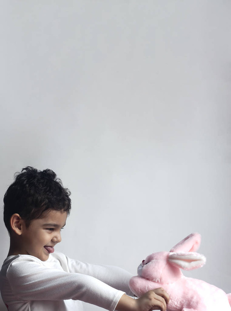 5 лет очаровательный маленький мальчик играет с плюшевым кроликом игрушкой
 - Фото, изображение
