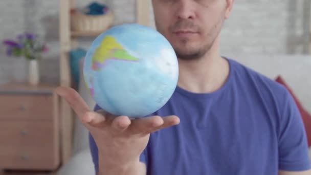 Close up globe spinning in the palm of a man slow mo - Video