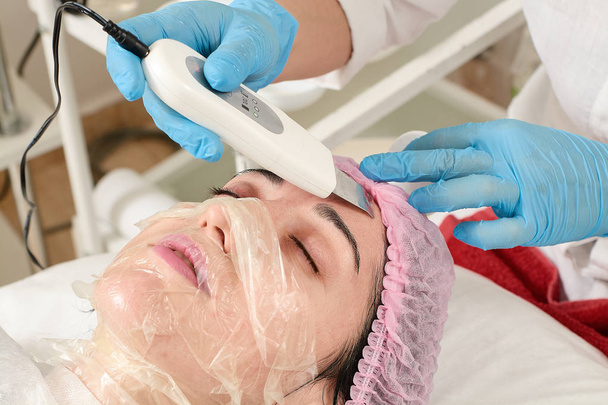 Jeune femme dans un salon de beauté faisant peeling et nettoyage du visage procédure
. - Photo, image