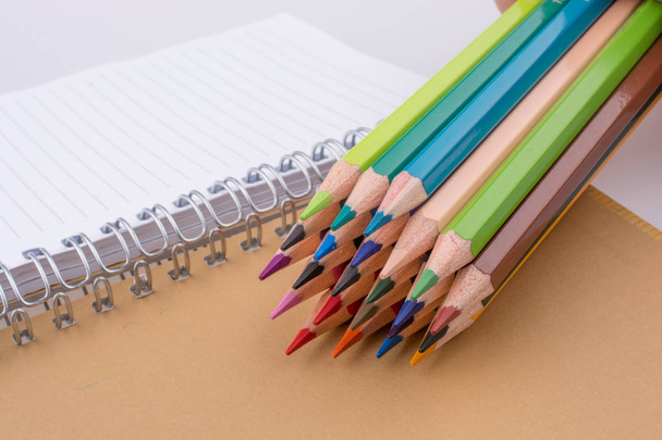 様々 な色の色鉛筆に近いノート - 写真・画像