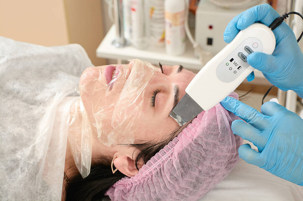 Mujer joven en el salón de belleza haciendo peeling y procedimiento de limpieza facial
. - Foto, imagen