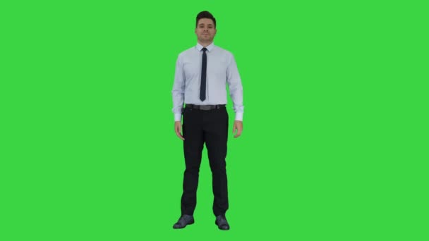 Joven hombre de negocios caminando en el marco y hablando con la cámara que presenta algo en una pantalla verde, Chroma Key
. - Metraje, vídeo
