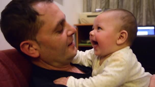 Père et son mignon six mois vieux bébé garçon câlins et parlant, passer un peu de temps de qualité ensemble - Séquence, vidéo