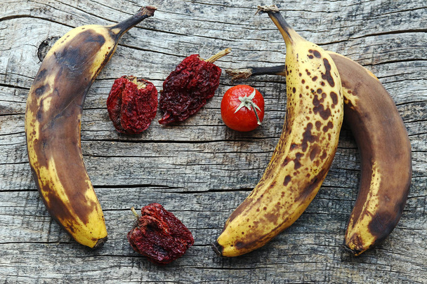 Staré hnědé banány a sušené papriky a rajčata. Staré ovoce a zelenina - Fotografie, Obrázek