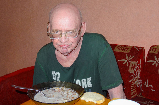 Old man eats food and thought about his life. - Foto, Imagen