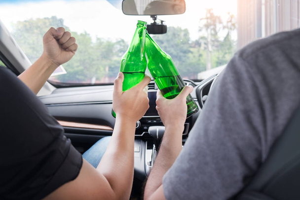 No bebas para conducir concepto, joven borracho bebiendo botella de cerveza o alcohol durante la conducción del coche peligrosamente
. - Foto, Imagen