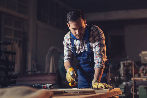 Young Carpenter finishing work  - Фото, изображение