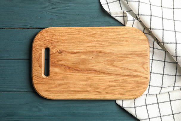 Kuchyňský ručník s řezná deska na dřevěné pozadí, pohled shora - Fotografie, Obrázek