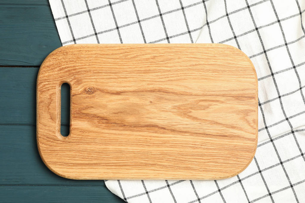 Πετσέτα κουζίνας με σανίδα κοπής σε ξύλινο φόντο, κορυφή θέα - Φωτογραφία, εικόνα