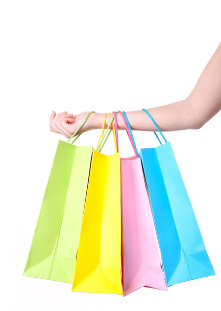 Hand holding multicolored paper bags isolated on white, shopping concept - Foto, Imagen