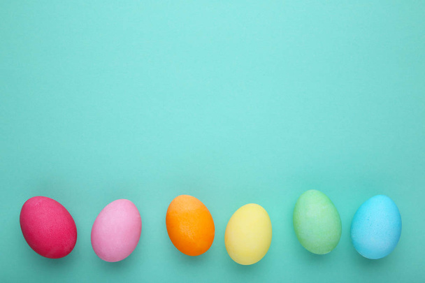 Colorful easter eggs on a mint background, flat lay - Foto, immagini