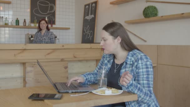 Απασχολημένη γυναίκα προγραμματιστής δουλεύοντας σε φορητό υπολογιστή στο καφέ - Πλάνα, βίντεο