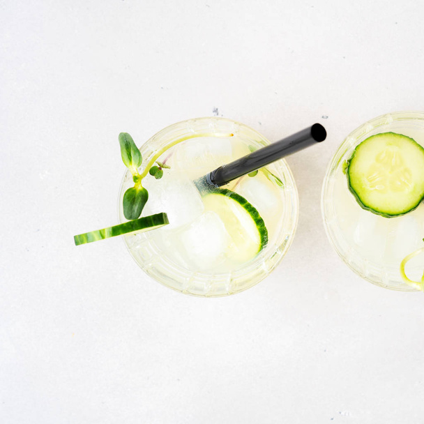 Fresh summer cocktail with cucumber garnished with cucumber slices, sprouts and micro greens - Foto, imagen