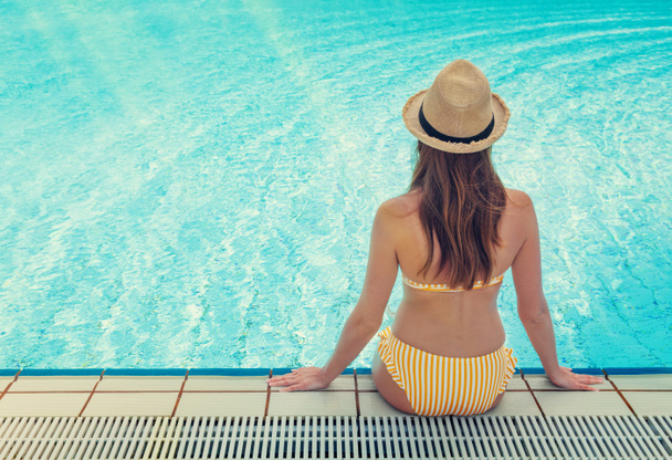 Young woman relaxing in swimming pool  - Fotoğraf, Görsel