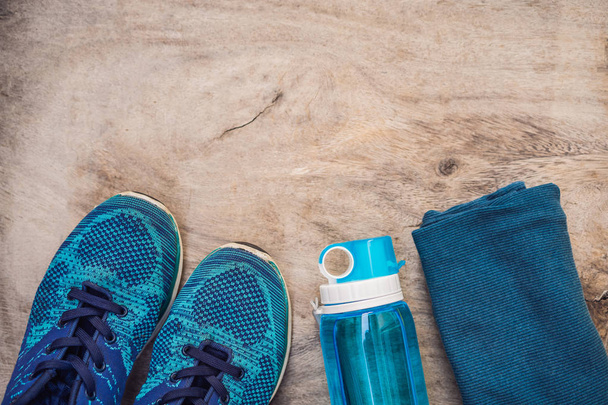 Everything for sports turquoise, blue shades on a wooden background. Yoga mat, sport shoes sportswear and bottle of water. Concept healthy lifestyle, sport and diet. Sport equipment. Copy space - Foto, immagini