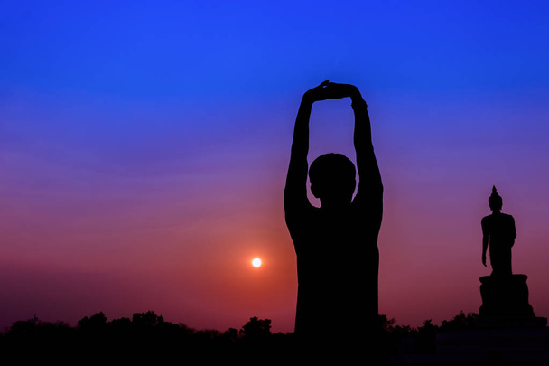 Siluetti mies meditointi ja jooga harjoitellaan liikunnan auringonnousun aikaan
 - Valokuva, kuva