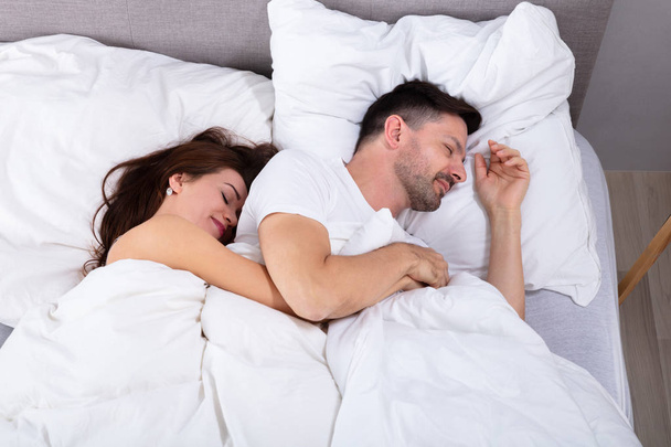 Young Loving Couple Sleeping On Bed With White Blanket - Foto, afbeelding