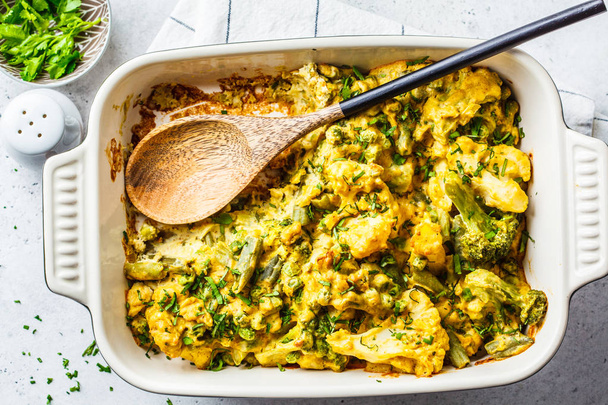 Broccoli, green peas and cauliflower cheese casserole in the ove - Photo, image