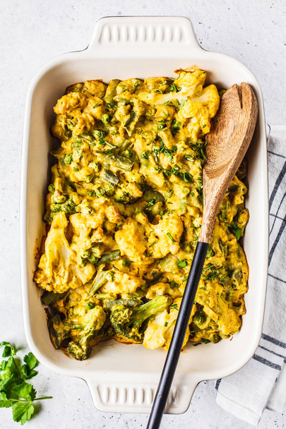 Broccoli, green peas and cauliflower cheese casserole in the ove - Foto, afbeelding