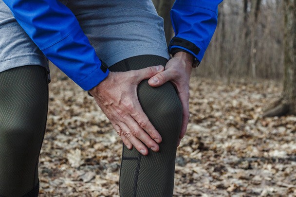 Člověk ve výcvikové šatně měl poraněné koleno při cvičení ve venkovním prostředí. Koncepce úrazu, techniky, špatného provozu, tendonitidy, velkého zatížení. - Fotografie, Obrázek