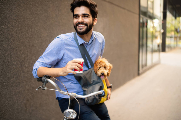 Handsome young businessman walking with his lovely dog. - Photo, Image