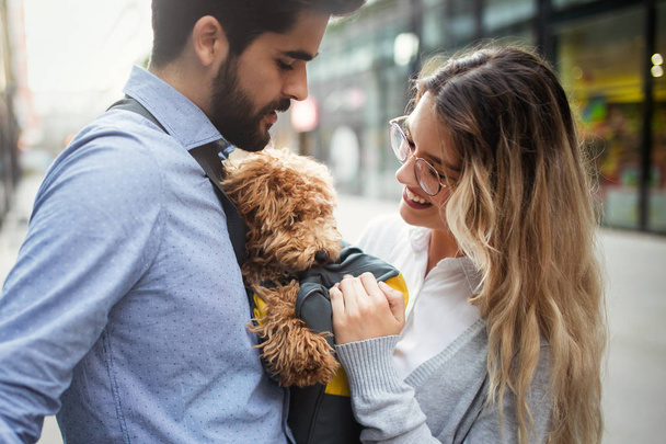 Happy couple in love with dog walking and smiling outdoor - 写真・画像