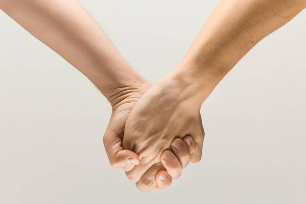  loseup shot of male holding hands isolated on grey studio background. - Foto, imagen