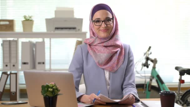 Professional young muslim business woman looking at camera laughing - Materiaali, video