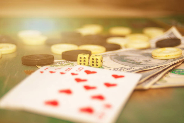 トランプ、ダイス、チップス、お金はカジノのギャンブルテーブルにあります. - 写真・画像